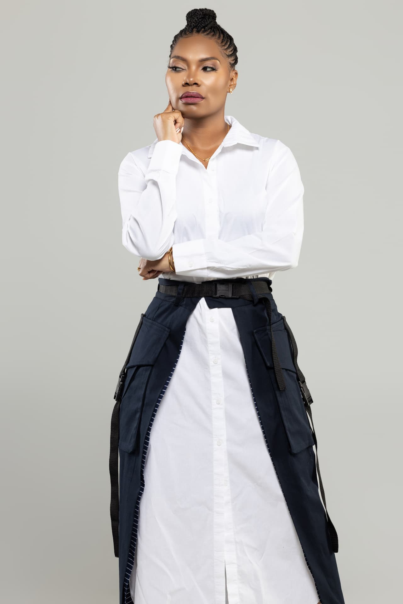 Dr. Tasha Mac standing with her hand at her chin, wearing a white shirt